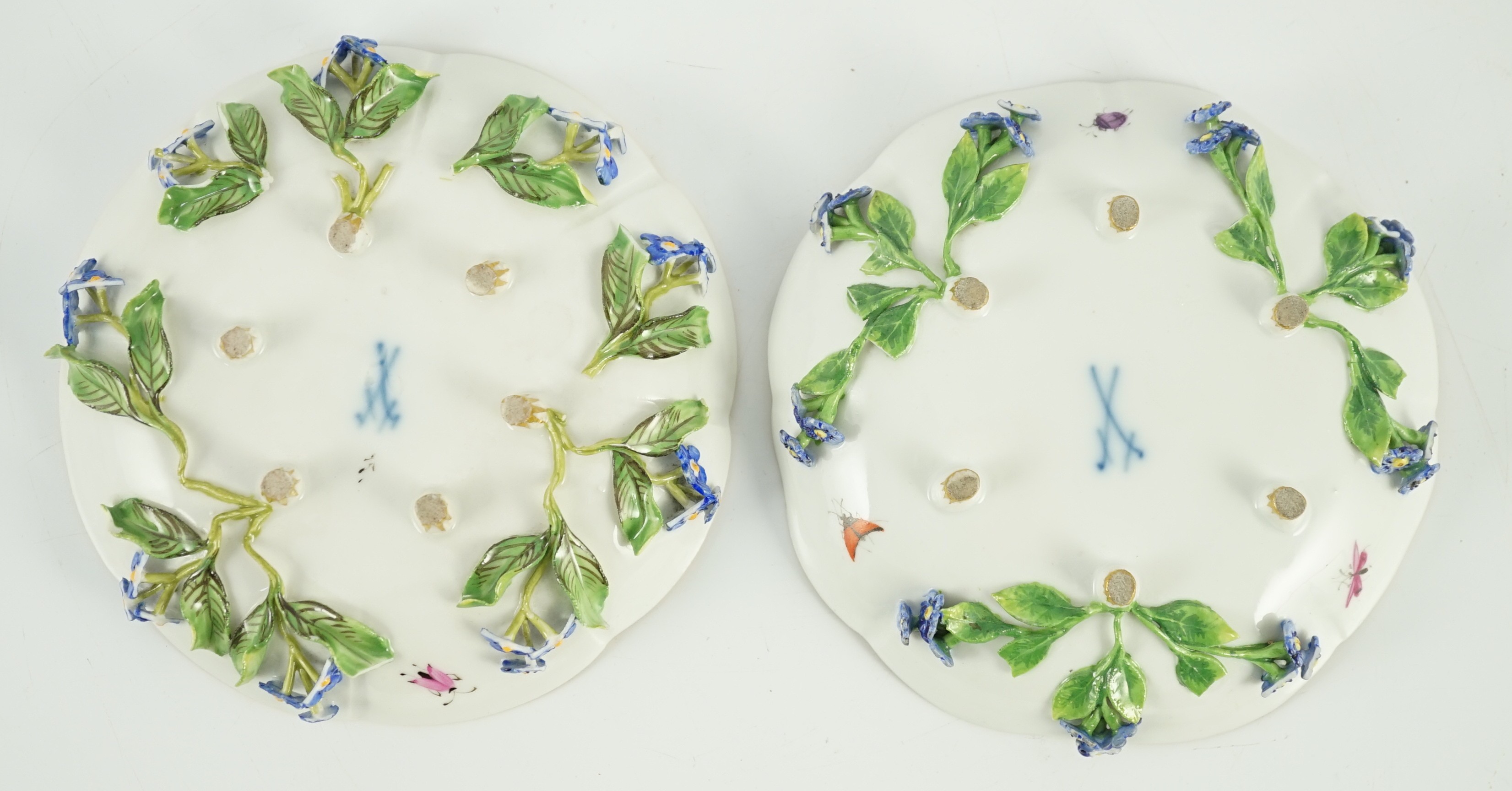 Two Meissen flower encrusted cups and saucers, 19th century, saucers 12cm wide, chips to flowers and leaves